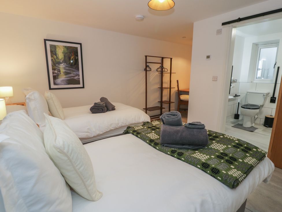 A bedroom with two beds and a bathroom at Y Côr Cerrigydrudion