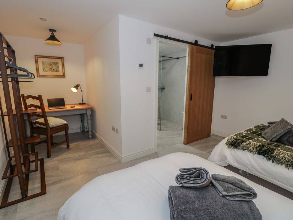 A bedroom with a bed, desk, and TV at Y Côr in Cerrigydrudion