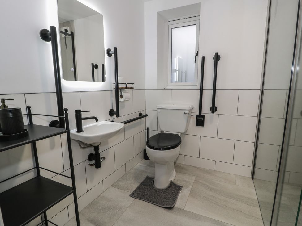 A bathroom with a sink, toilet, and shower at Y Côr in Cerrigydrudion