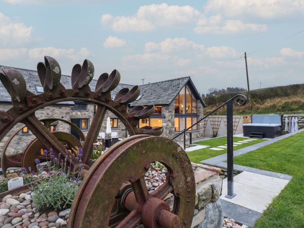 An outdoor area with a rusty wheel and hot tub at Y Côr in Cerrigydrudion
