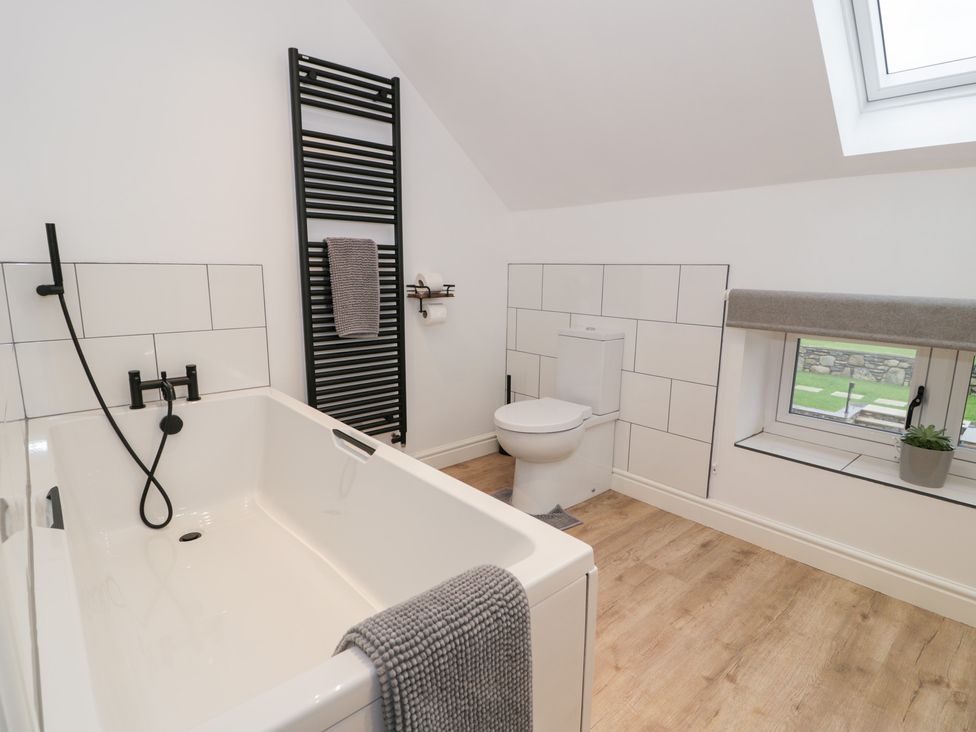 A bathroom with a bathtub and toilet at Y Côr in Cerrigydrudion