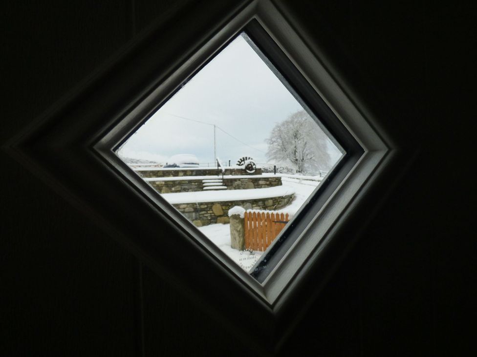 A view of snow-covered landscape through a window at Y Côr in Cerrigydrudion