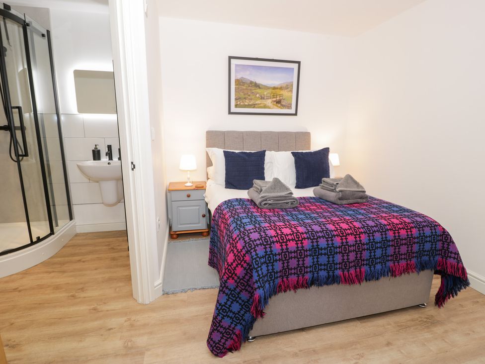 A bedroom with a bed and an attached bathroom at Y Côr in Cerrigydrudion