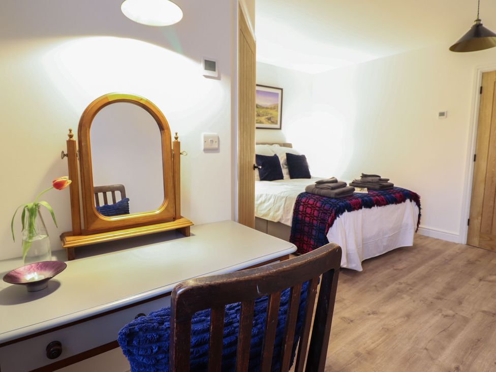 A bedroom with a bed and a mirror at Y Côr in Cerrigydrudion