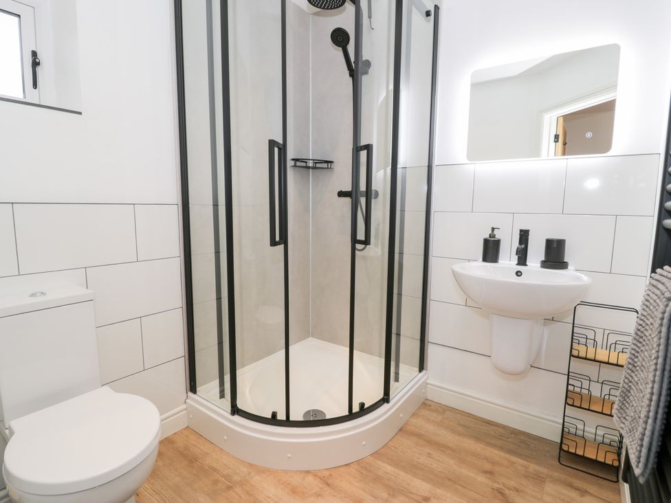 A bathroom with a shower, toilet, and sink at Y Côr in Cerrigydrudion