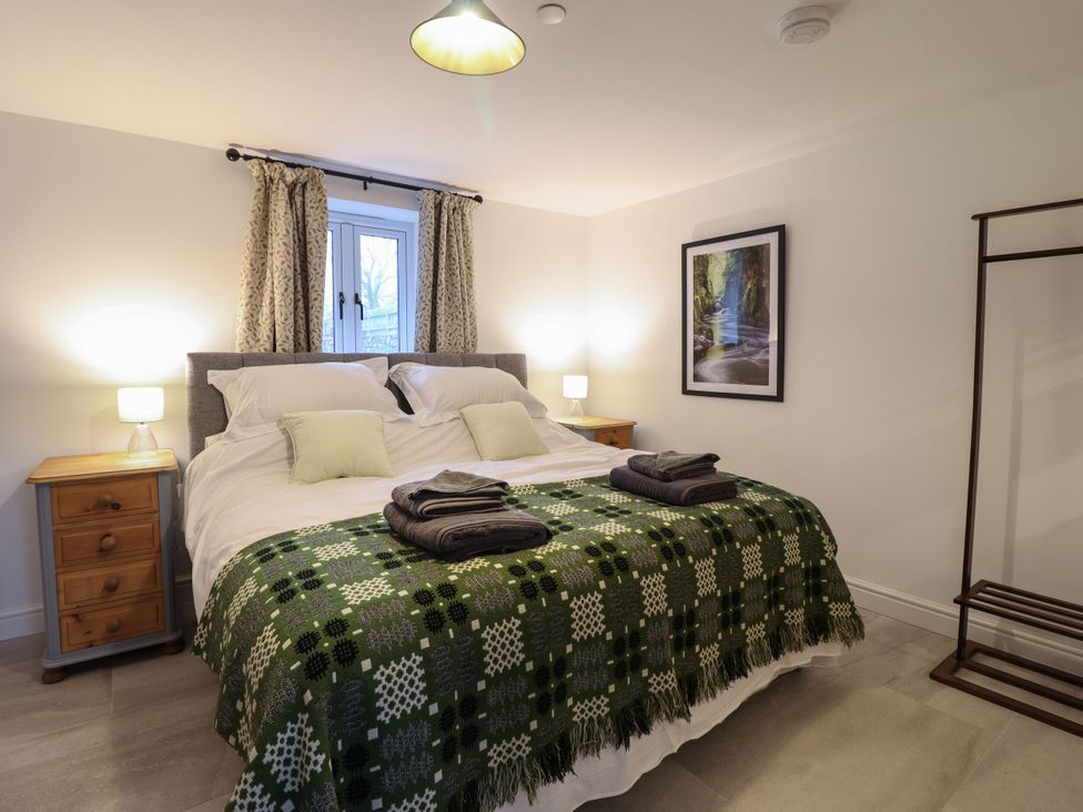 A bedroom with a bed and bedside tables at Y Côr in Cerrigydrudion