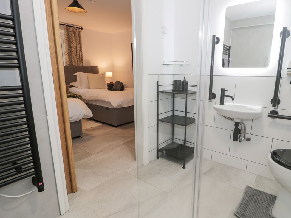 A bathroom with a shower, sink, and toilet at Y Côr in Cerrigydrudion