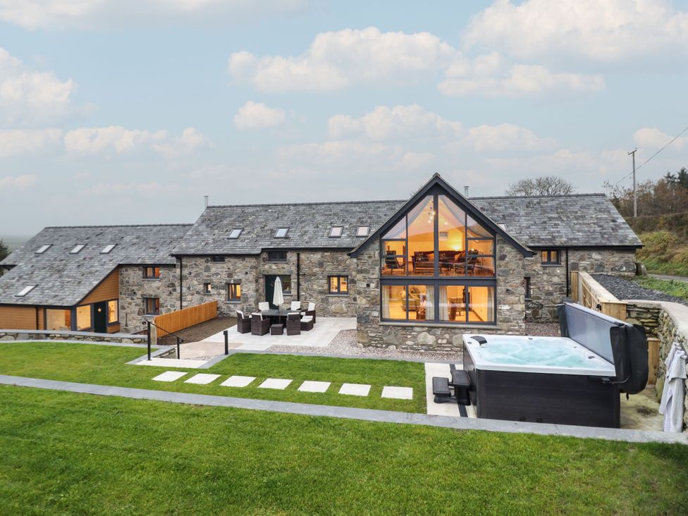 A house with outdoor furniture and a hot tub at Y Côr in Cerrigydrudion