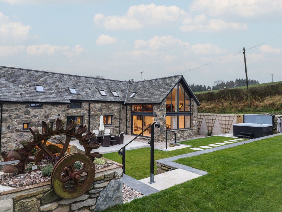 An outdoor space with a hot tub and garden features at Y Côr in Cerrigydrudion