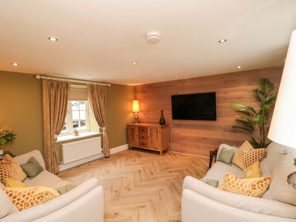 A living room with a sofa and television at Clematis Cottage in Whitby