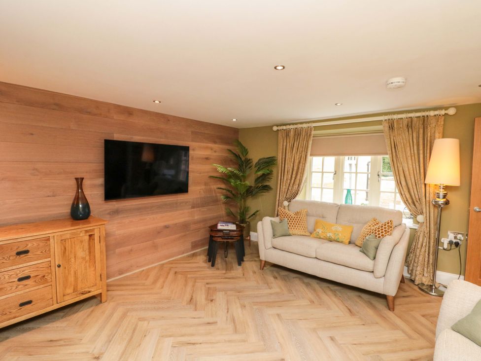 A living room with a television and sofa at Clematis Cottage in Whitby