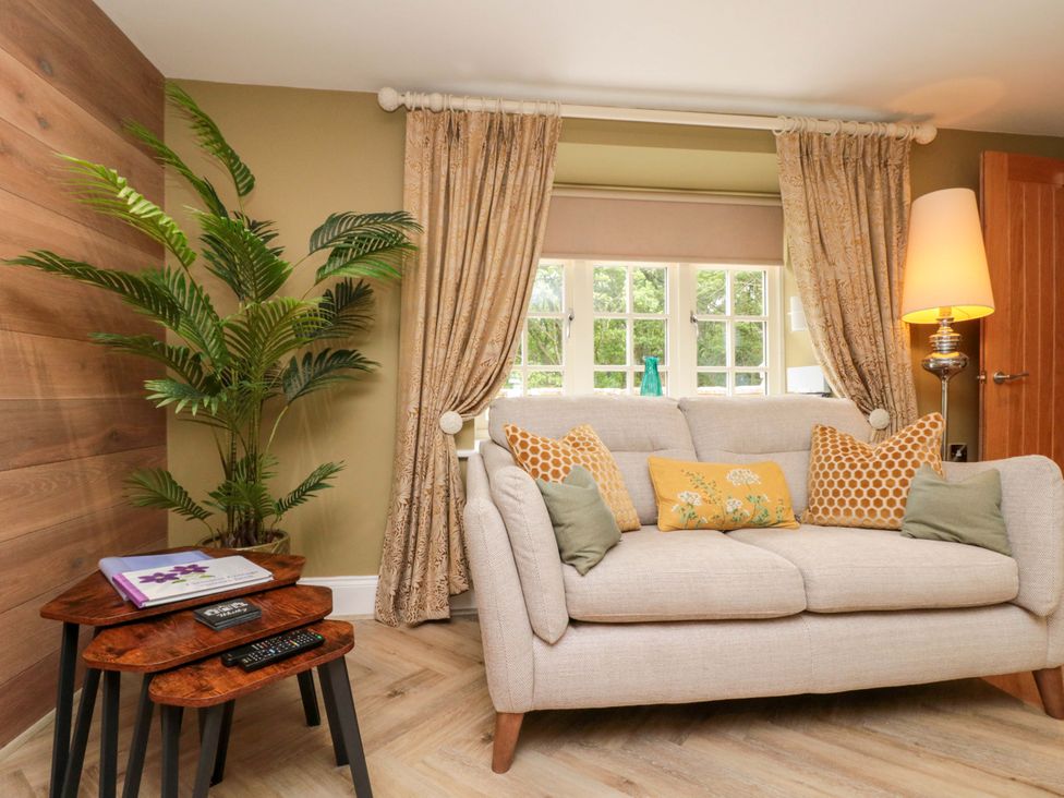 A living room with a sofa and side table at Clematis Cottage in Whitby