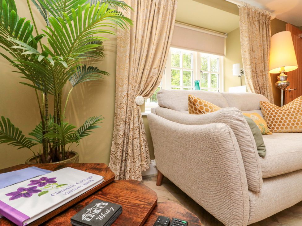 A living room with a sofa and cushions at Clematis Cottage in Whitby