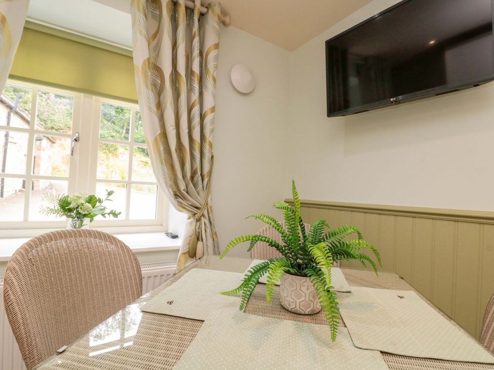 A dining room with a table and chairs at Clematis Cottage in Whitby