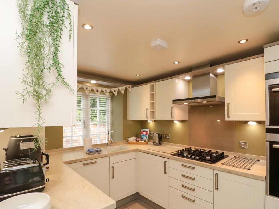 A kitchen with stove and kettle at Clematis Cottage in Whitby