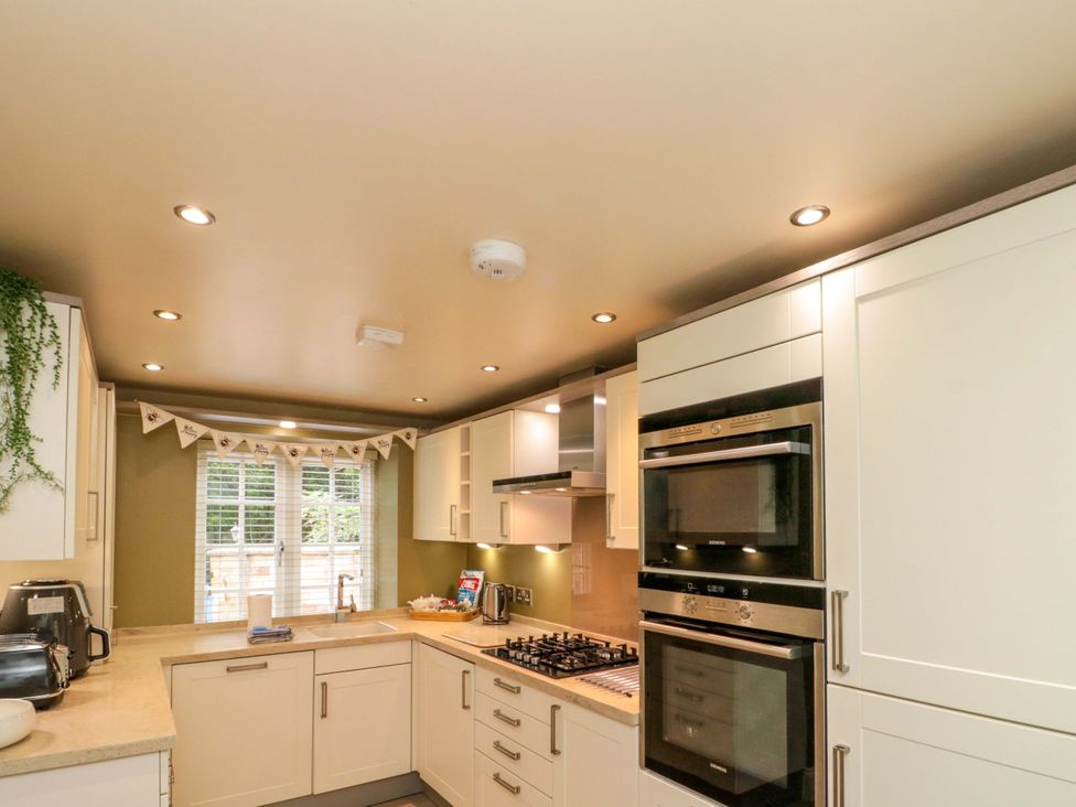 A kitchen with modern cabinets and appliances at Clematis Cottage in Whitby