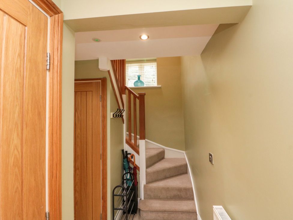 A hallway with stairs leading up at Clematis Cottage in Whitby