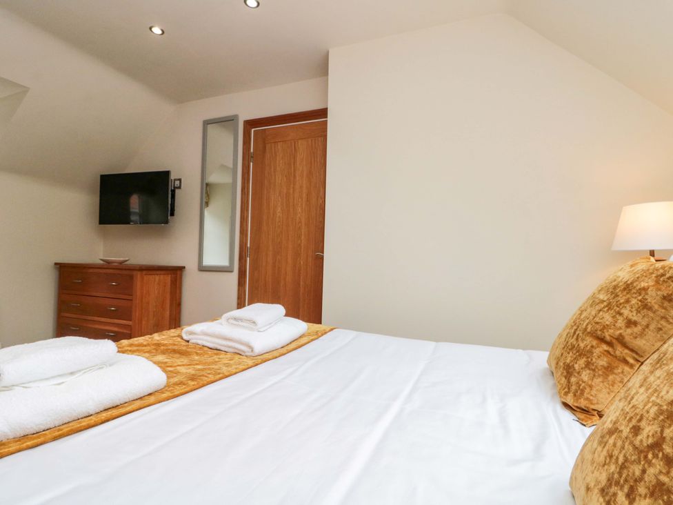 A bedroom with a bed and television at Clematis Cottage in Whitby