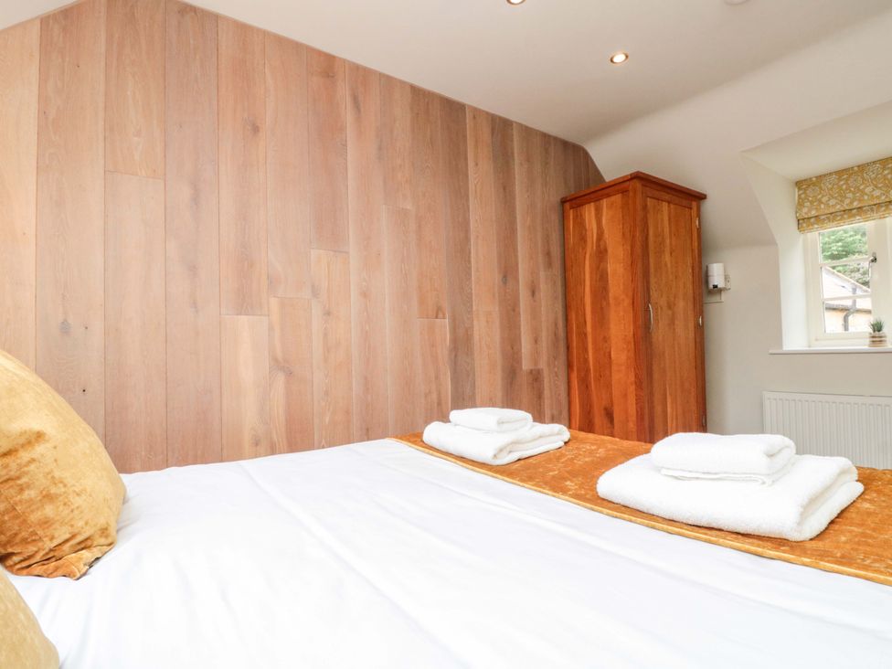 A bedroom with a bed and wardrobe at Clematis Cottage in Whitby