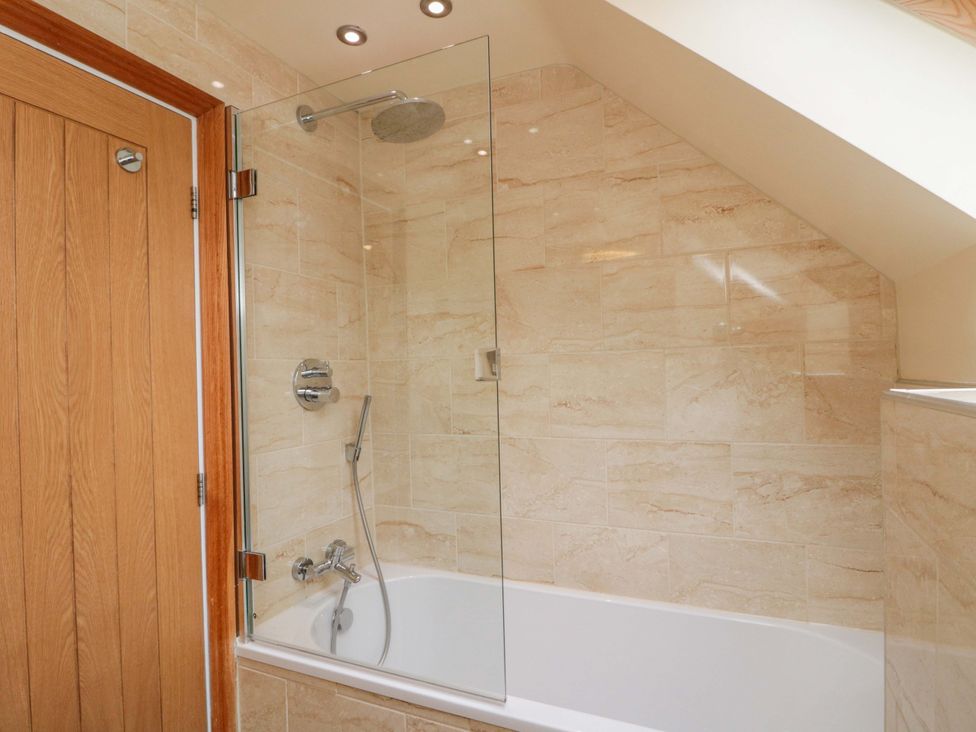 A bathroom with a bathtub and a shower at Clematis Cottage in Whitby