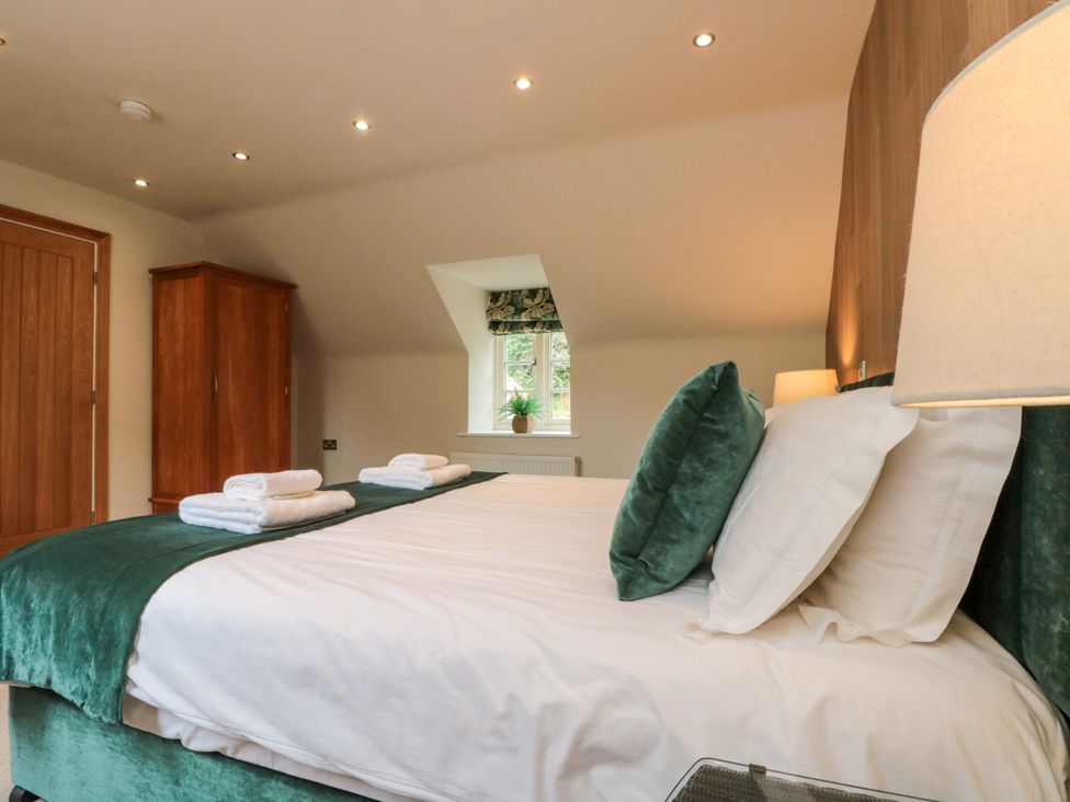 A bedroom with a bed and wardrobe at Clematis Cottage in Whitby