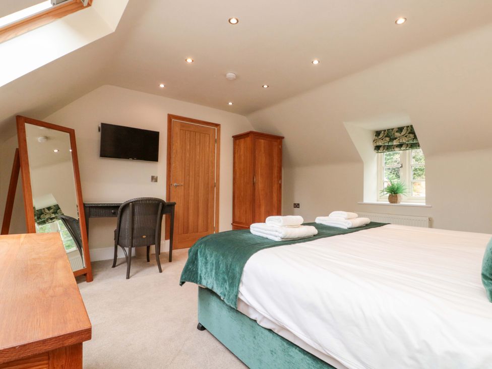 A bedroom with a bed and a desk at Clematis Cottage in Whitby