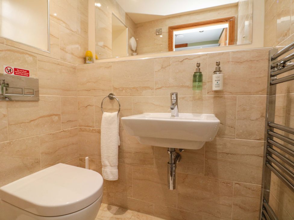 A bathroom with a toilet and wash basin at Clematis Cottage in Whitby