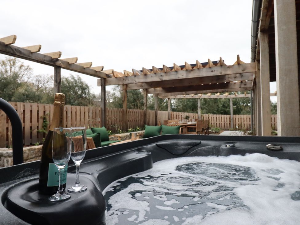 A hot tub with champagne and glasses in an outdoor area at Lower Moorwood Moorwood near Bovey Tracey