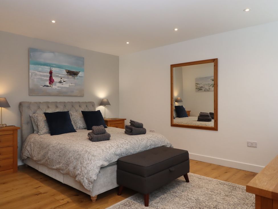 A bedroom with a bed and nightstands at Lower Moorwood in Moorwood near Bovey Tracey