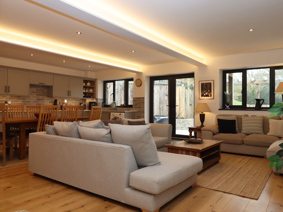 A living room with a sofa and dining area at Lower Moorwood in Moorwood near Bovey Tracey