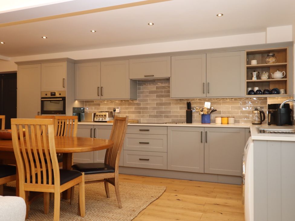 A kitchen with a dining table and various appliances at Lower Moorwood in Moorwood near Bovey Tracey