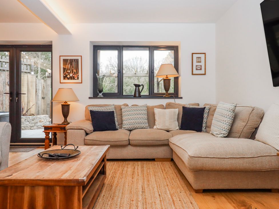 A living room with a sofa, table, and lamp at Lower Moorwood in Moorwood near Bovey Tracey