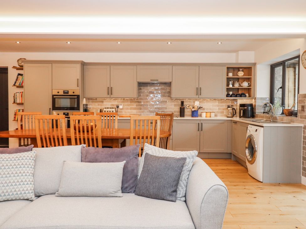 A kitchen with dining table and appliances at Lower Moorwood Moorwood near Bovey Tracey