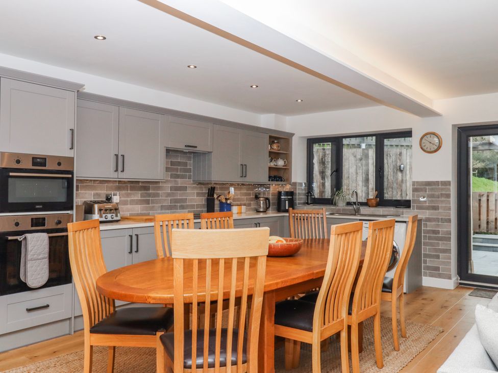 A kitchen with a dining table and chairs at Lower Moorwood Moorwood near Bovey Tracey