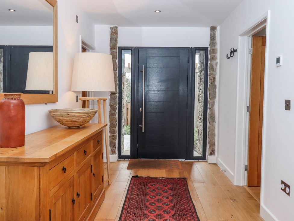 A hallway with a console table and front door at Lower Moorwood Moorwood near Bovey Tracey
