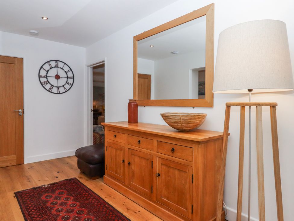 A hallway with a clock and lamp at Lower Moorwood in Moorwood near Bovey Tracey