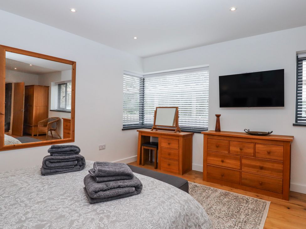 A bedroom with a bed and dresser at Lower Moorwood Moorwood near Bovey Tracey