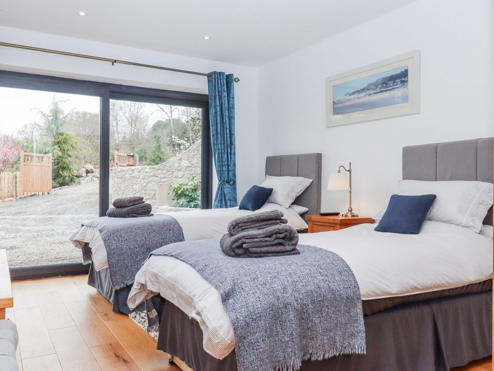 A bedroom with two beds and a view of the garden at Lower Moorwood in Moorwood near Bovey Tracey