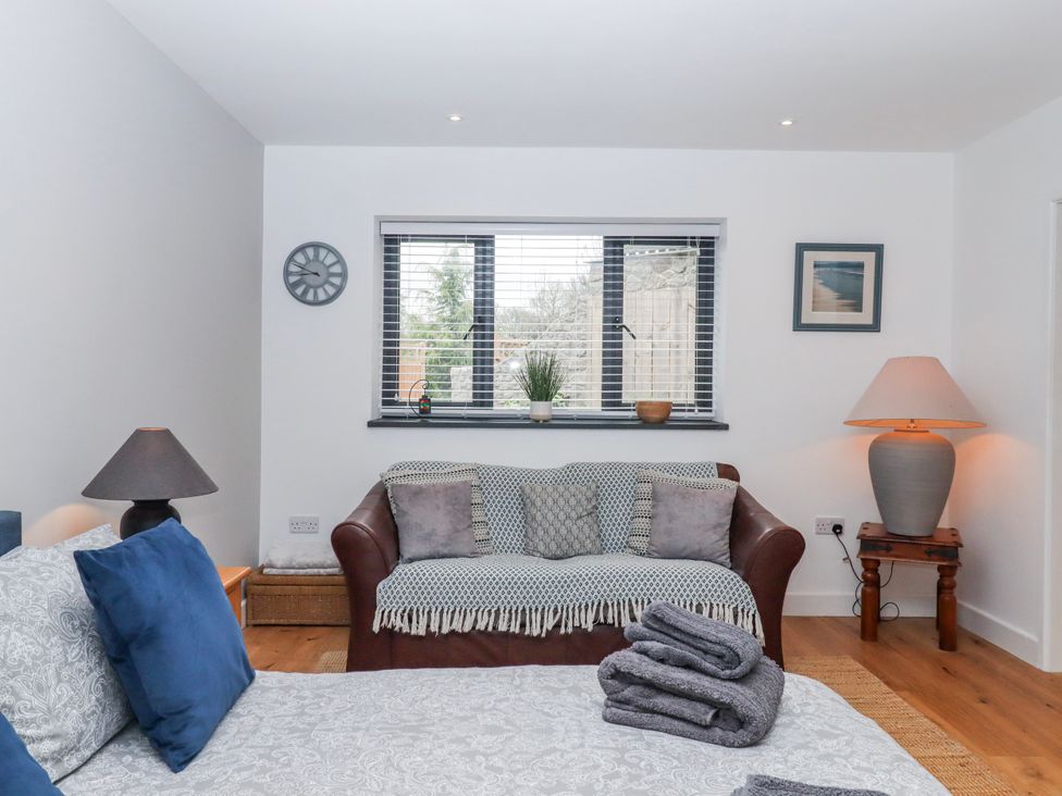 A bedroom with a sofa and window at Lower Moorwood in Moorwood near Bovey Tracey