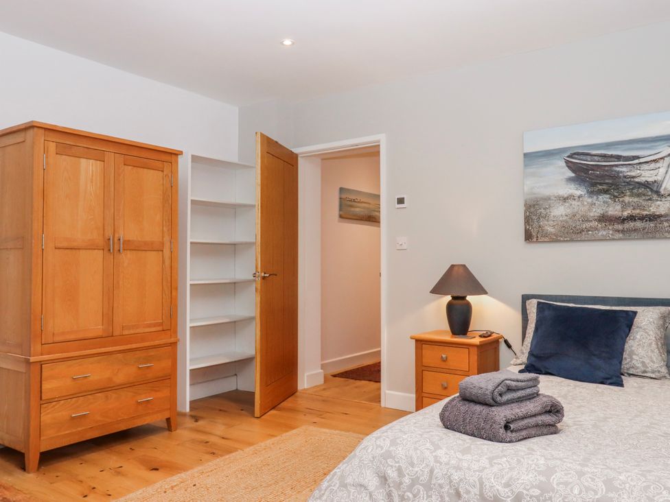 A bedroom with a bed and wardrobe at Lower Moorwood in Moorwood near Bovey Tracey