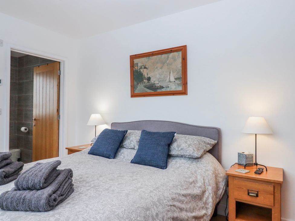 A bedroom with a bed and nightstand at Lower Moorwood in Moorwood near Bovey Tracey