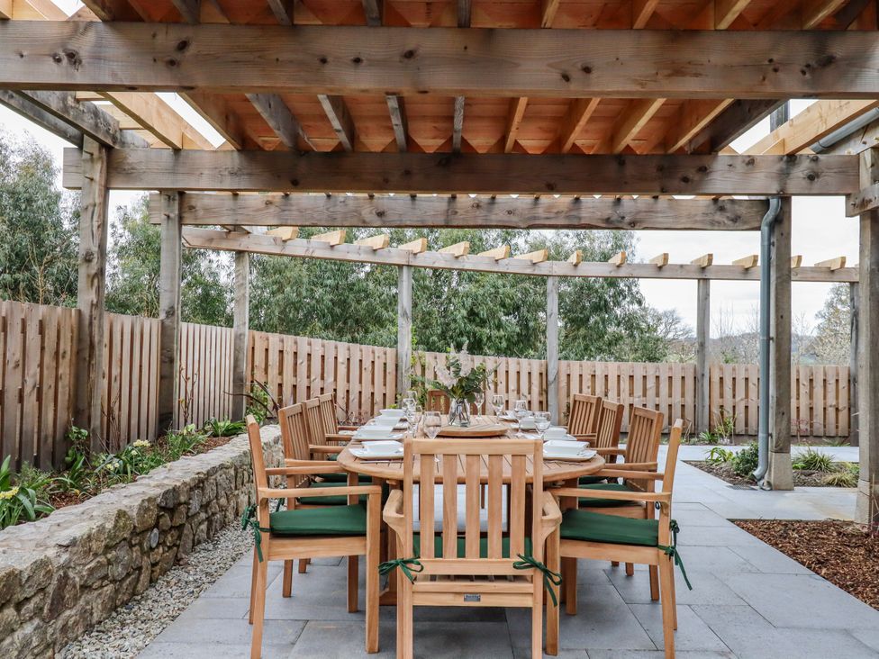 An outdoor dining area with a table and chairs at Lower Moorwood in Moorwood near Bovey Tracey