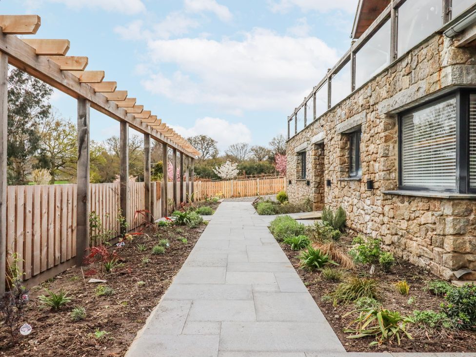 A garden pathway beside a house with a pergola at Lower Moorwood near Bovey Tracey