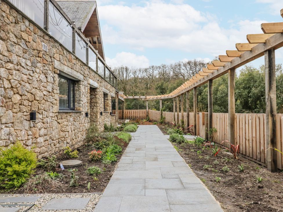 A garden with a stone wall and a pathway at Lower Moorwood in Moorwood near Bovey Tracey