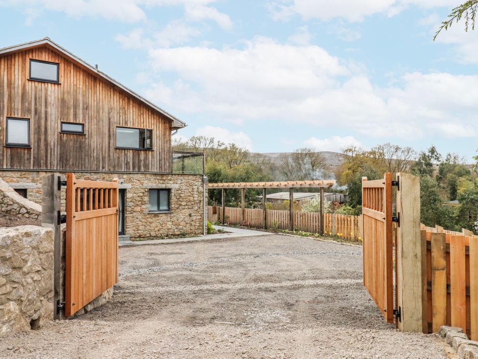 An outdoor view of a house with a wooden gate and gravel driveway at Lower Moorwood in Moorwood near Bovey Tracey