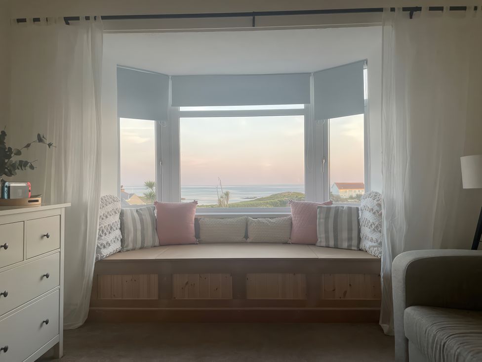 A living room with a window seat and cushions at Plas Darien Apartment 7 Trearddur Bay