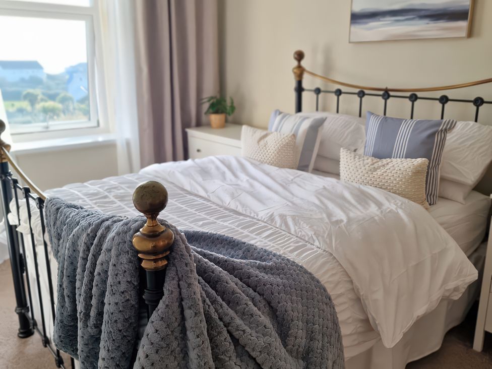 A bedroom with a bed and window at Plas Darien Apartment 7 Trearddur Bay