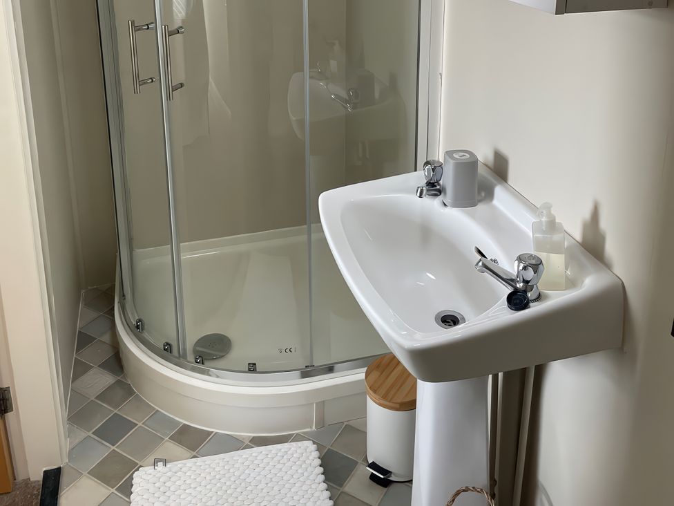 A bathroom with a shower and sink at Plas Darien Apartment 7 in Trearddur Bay