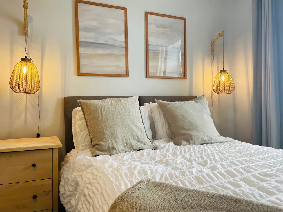 A bedroom with a bed and lamps at Plas Darien Apartment 7 Trearddur Bay