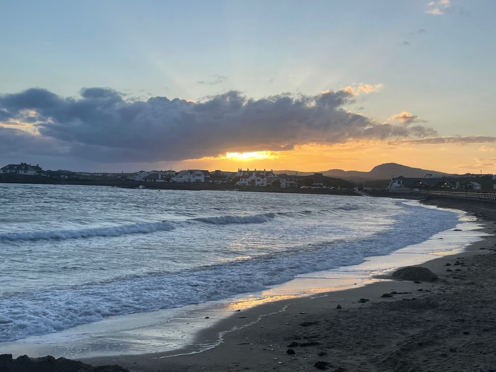 A beach with waves and sunset at No.7 Plas Darien Trearddur Bay
